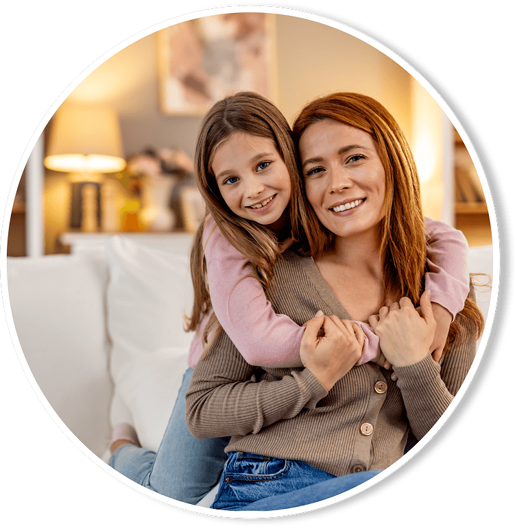 Daughter hugging daughter on couch in their Louisiana home.